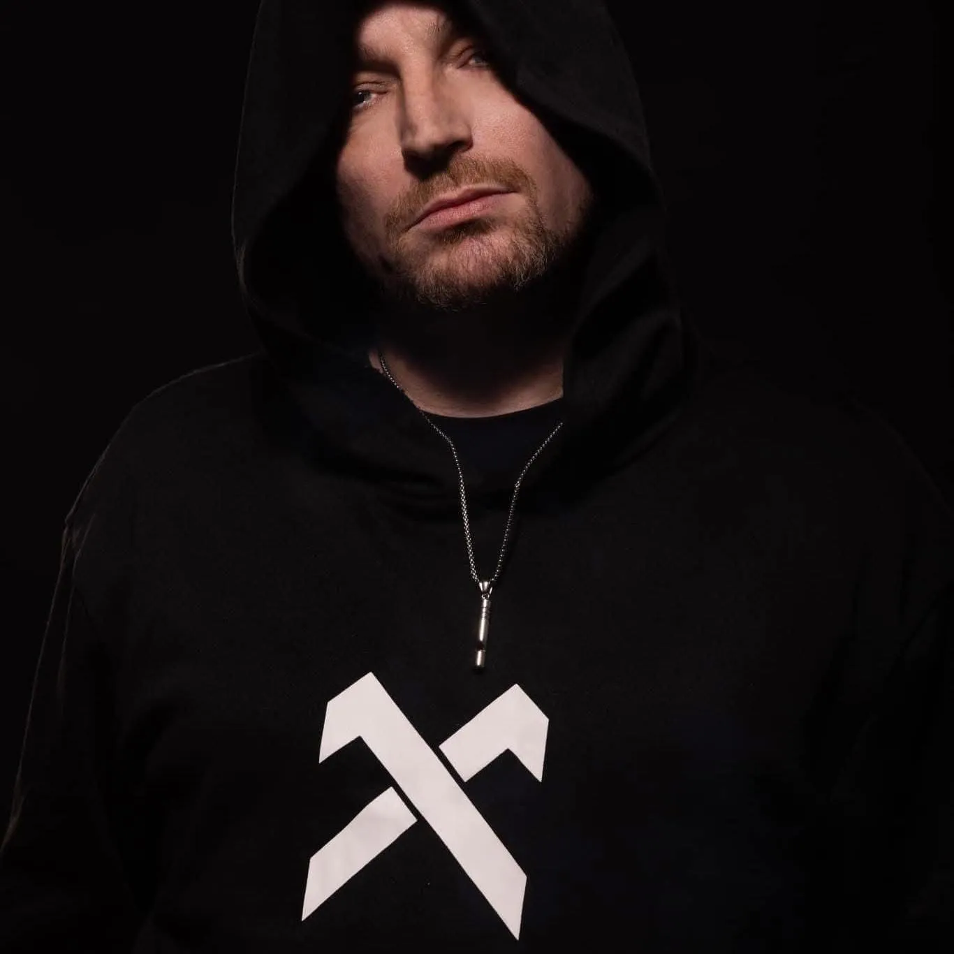 Carl Nicholson in a black hoodie against a dark studio background