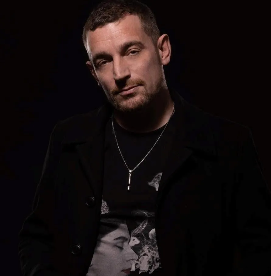 Carl Nicholson in a black jacket against a dark background