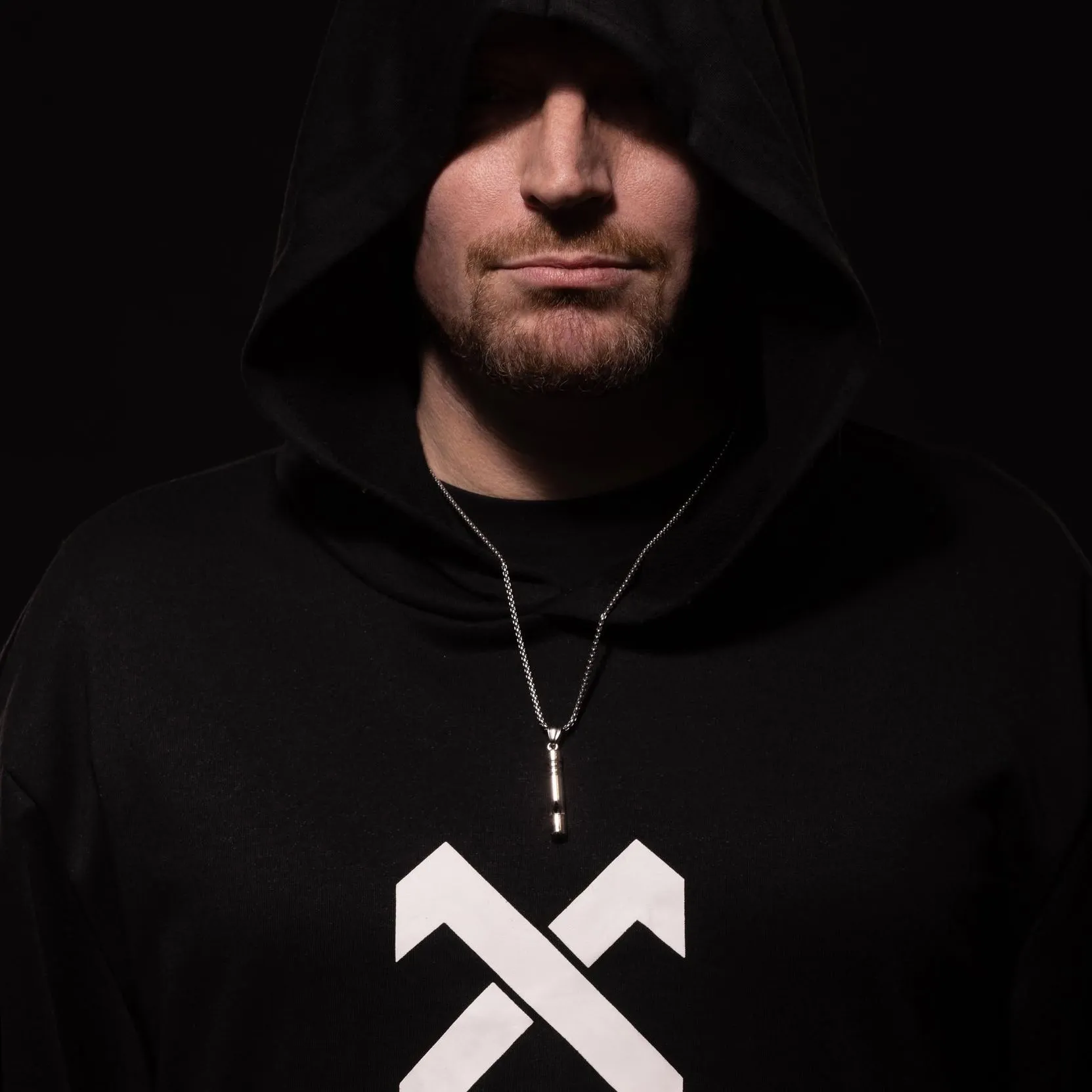 NICHOLSON in a black hood, photographed against a dark background